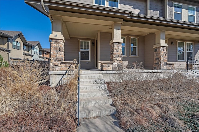 property entrance featuring covered porch and stone siding