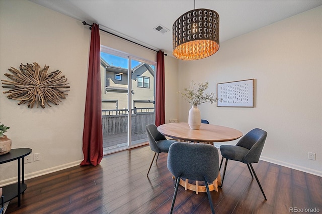 dining room with a notable chandelier, wood finished floors, visible vents, and baseboards