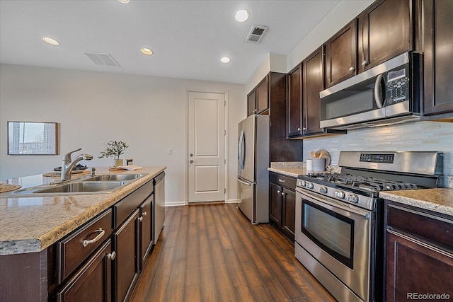 kitchen featuring stainless steel appliances, visible vents, a sink, and backsplash