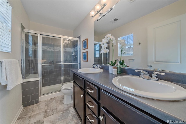 bathroom with toilet, a shower stall, visible vents, and a sink