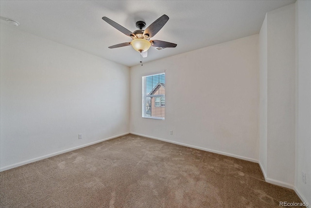 carpeted empty room featuring ceiling fan and baseboards