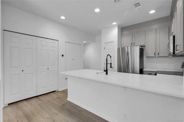 1409 Carlyle Park Cir, Highlands Ranch, CO 80129 - kitchen featuring appliances with stainless steel finishes, gray cabinetry, light countertops, light wood-style flooring, and recessed lighting