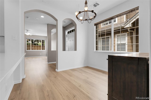 1409 Carlyle Park Cir, Highlands Ranch, CO 80129 - unfurnished dining area featuring arched walkways, light wood-style floors, and a chandelier