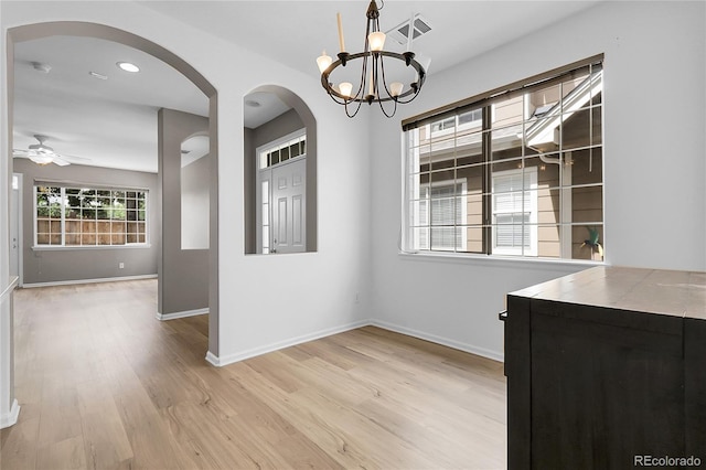 1409 Carlyle Park Cir, Highlands Ranch, CO 80129 - unfurnished dining area featuring light wood finished floors, a chandelier, arched walkways, a ceiling fan, and recessed lighting