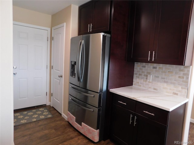 kitchen featuring tasteful backsplash, dark wood finished floors, stainless steel fridge with ice dispenser, light stone counters, and dark brown cabinets