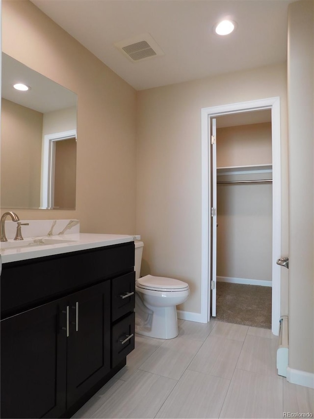 bathroom featuring toilet, recessed lighting, vanity, baseboards, and visible vents