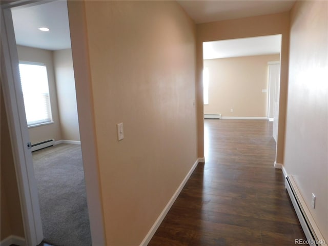 corridor featuring a baseboard heating unit, dark wood-style flooring, a baseboard radiator, and baseboards