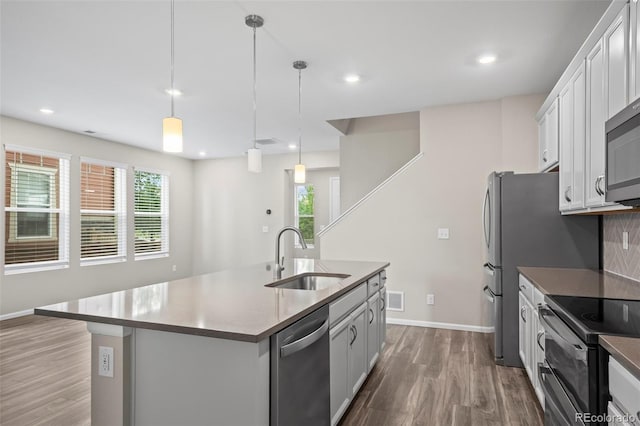 13870 Ash Cir, Brighton, CO 80602 - kitchen with stainless steel appliances, dark wood-type flooring, a center island with sink, recessed lighting, and pendant lighting