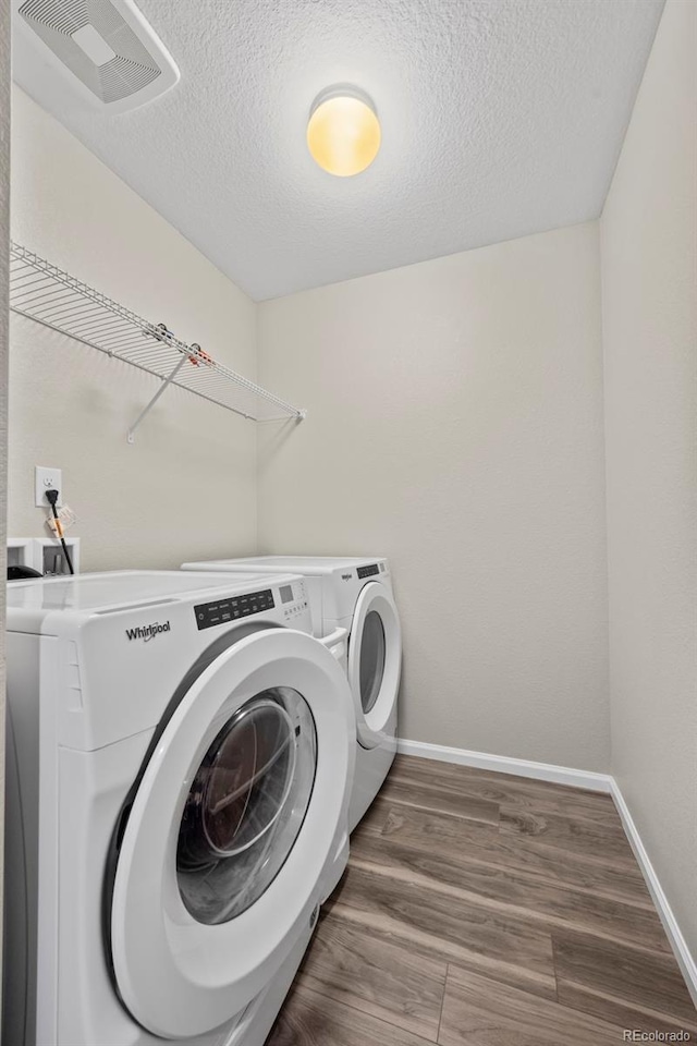 13870 Ash Cir, Brighton, CO 80602 - laundry room featuring independent washer and dryer, a textured ceiling, and wood finished floors