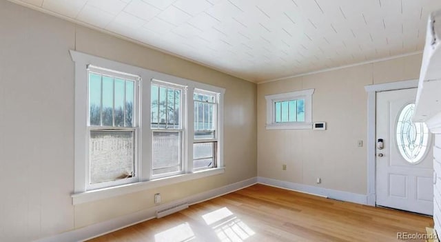 entryway featuring crown molding, baseboards, visible vents, and light wood-style floors