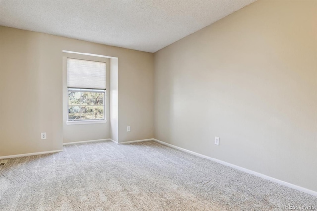 unfurnished room featuring a textured ceiling and light carpet