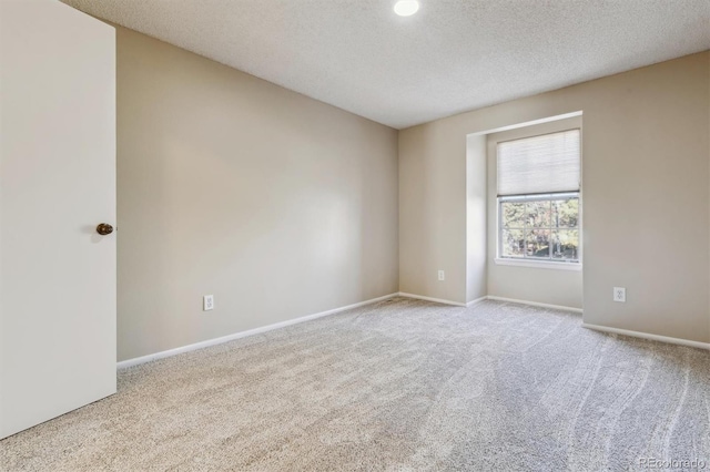 carpeted spare room with a textured ceiling