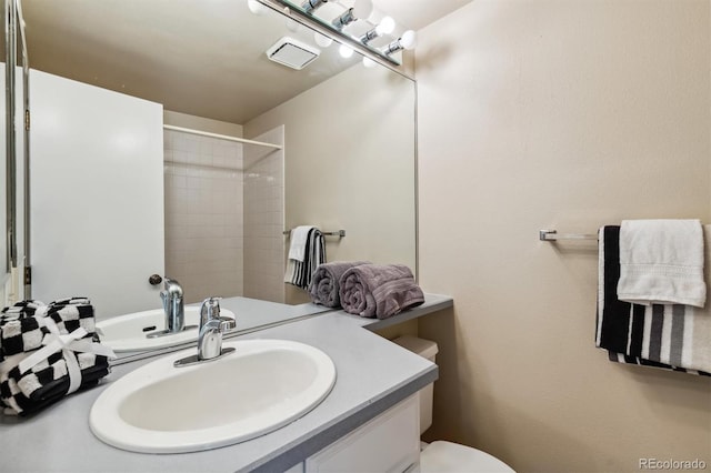 bathroom with a shower, vanity, and toilet