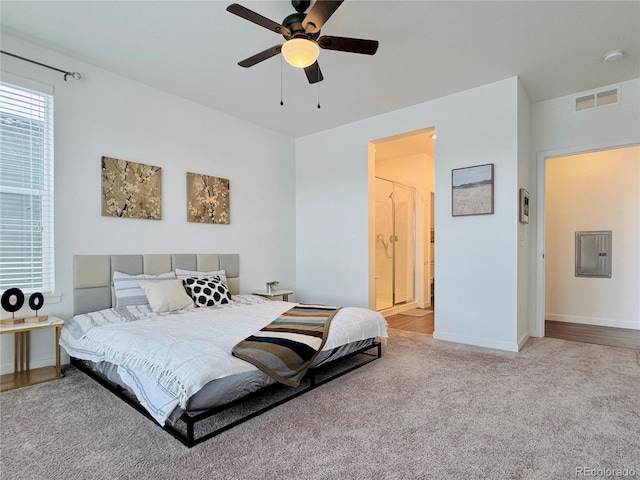 carpeted bedroom featuring ensuite bathroom, electric panel, and ceiling fan