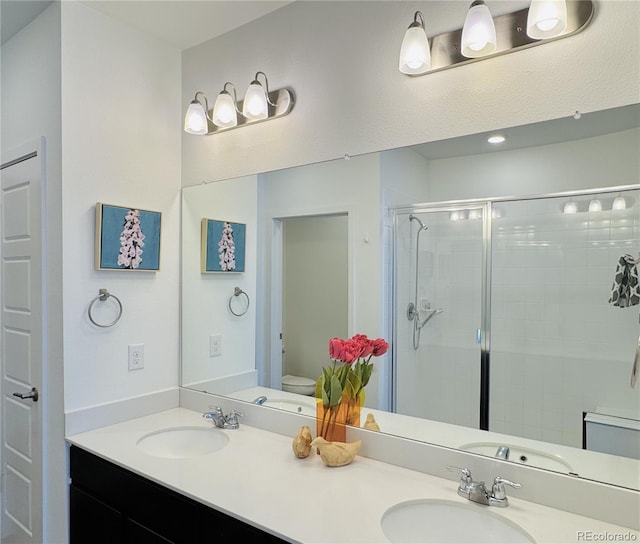 bathroom with vanity, a shower with shower door, and toilet