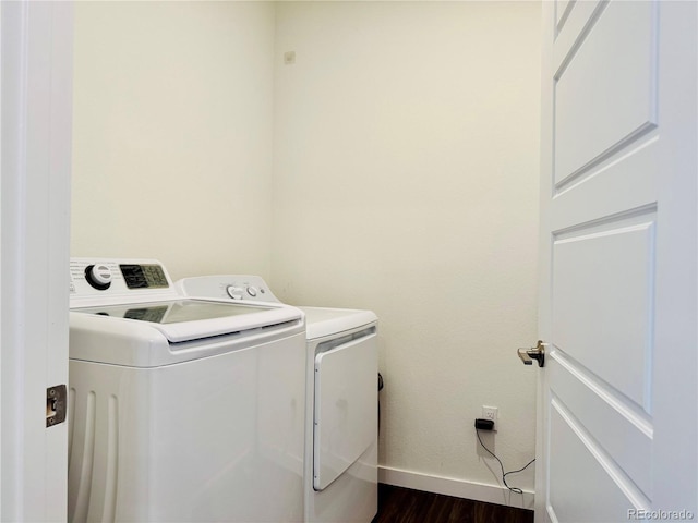 clothes washing area with dark hardwood / wood-style flooring and independent washer and dryer