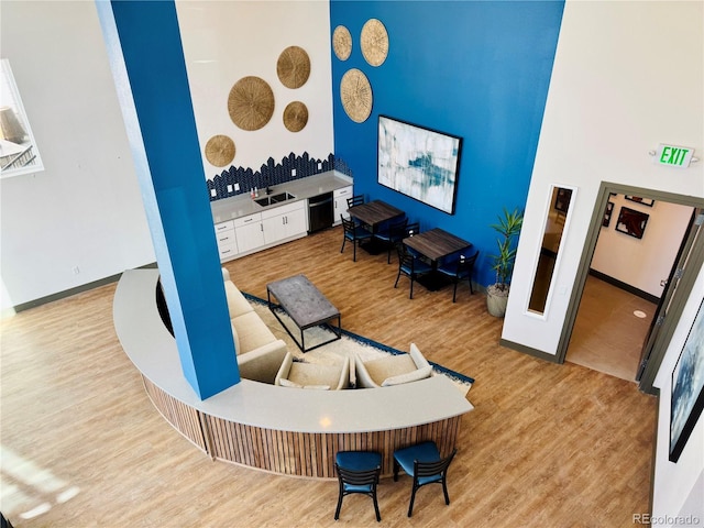 living room with wood-type flooring, sink, and a high ceiling