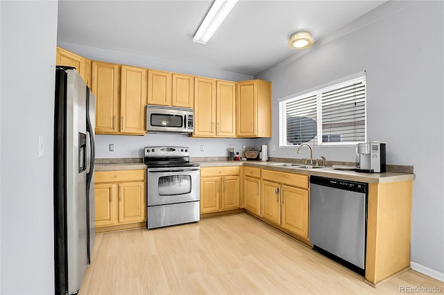 kitchen with light wood-type flooring, stainless steel appliances, light brown cabinetry, and a sink