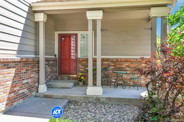 14944 E Archer Cir, Aurora, CO 80012 - view of exterior entry featuring a porch and brick siding