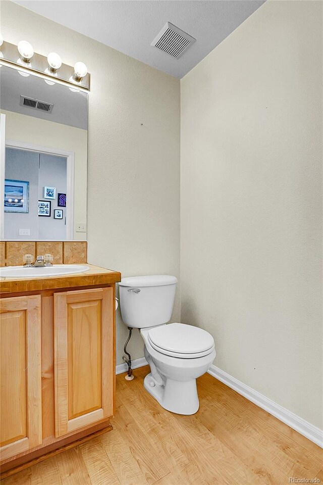 14944 E Archer Cir, Aurora, CO 80012 - bathroom with toilet, wood finished floors, vanity, and baseboards