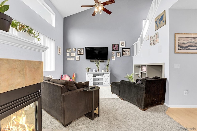 14944 E Archer Cir, Aurora, CO 80012 - living area with high vaulted ceiling, ceiling fan, a tile fireplace, baseboards, and light carpet