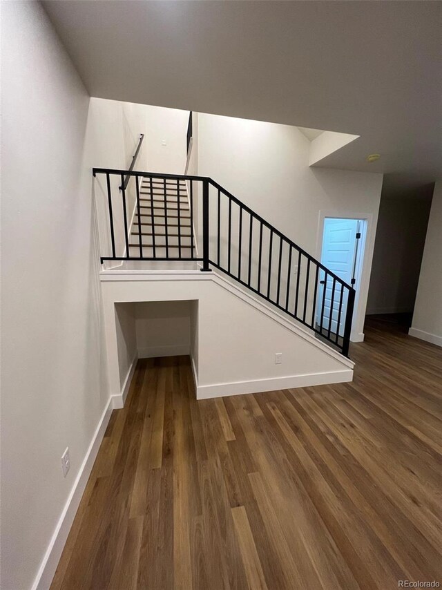 staircase with wood finished floors and baseboards