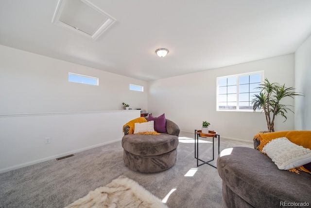 living area with visible vents, carpet, attic access, and a healthy amount of sunlight