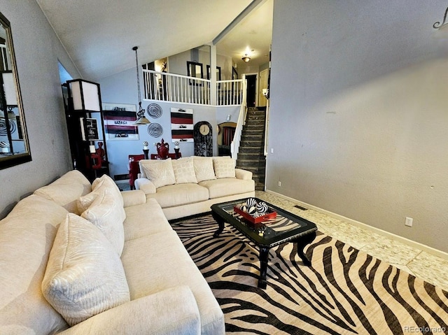 living area featuring visible vents, high vaulted ceiling, and stairway