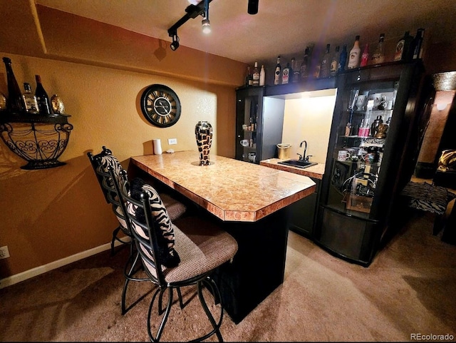 bar featuring light carpet, wet bar, and a sink