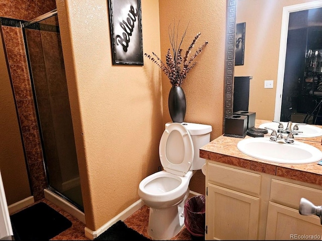bathroom with toilet, a stall shower, a textured wall, and vanity