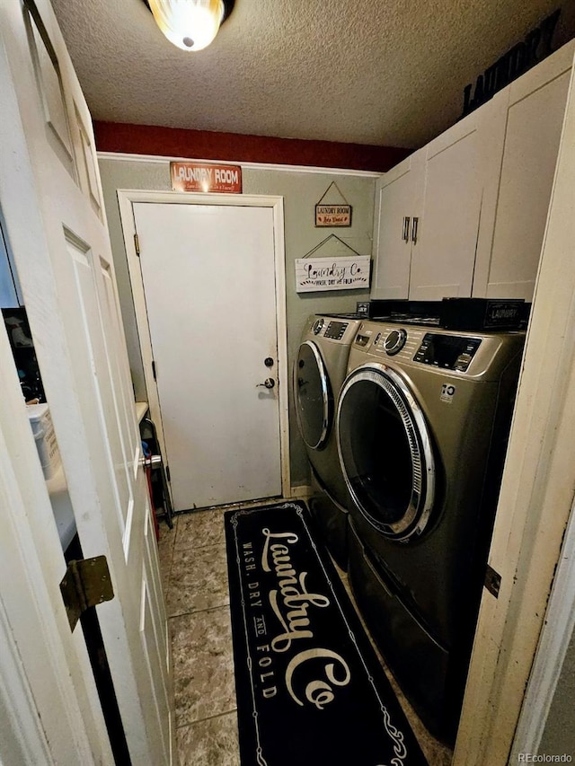 laundry room featuring independent washer and dryer, a textured ceiling, and cabinet space