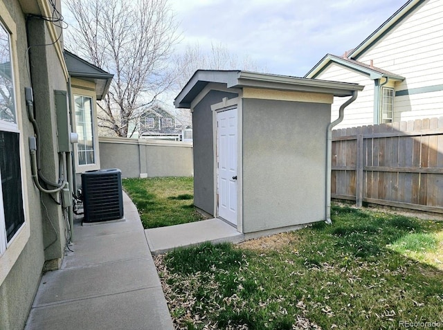 view of shed featuring fence and cooling unit