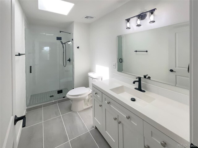 bathroom with vanity, tile patterned flooring, a stall shower, and toilet