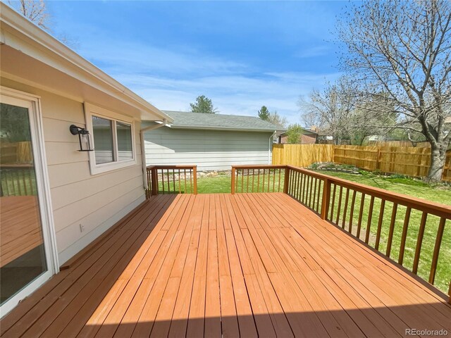 wooden terrace featuring fence and a yard
