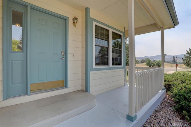 entrance to property with a mountain view and covered porch