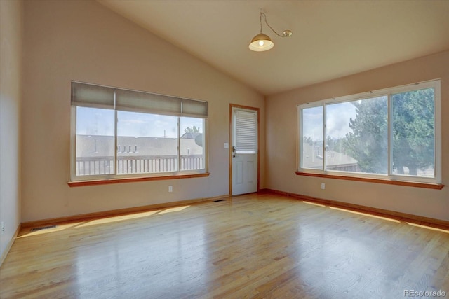 spare room with light hardwood / wood-style floors and vaulted ceiling