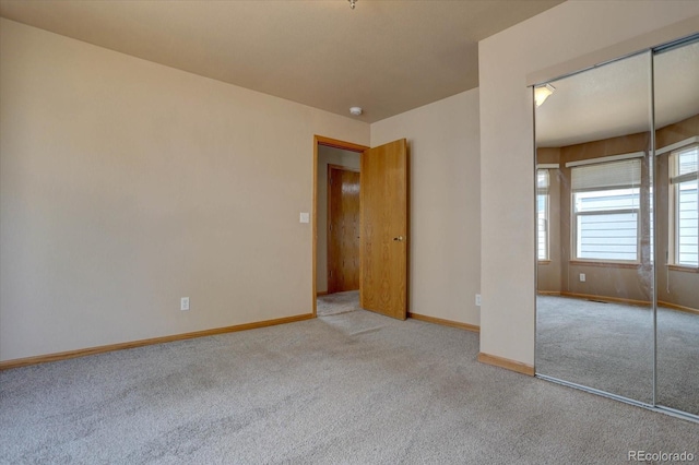 unfurnished bedroom featuring a closet and light colored carpet