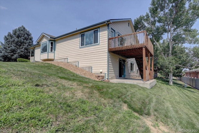 view of side of home featuring a lawn, a patio area, and a deck