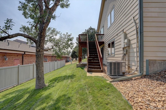 view of yard featuring cooling unit, fence, a wooden deck, and stairs