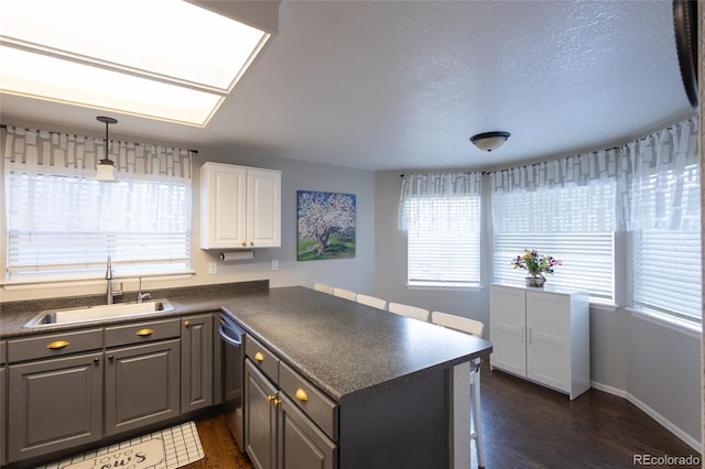 kitchen featuring gray cabinets, white cabinetry, sink, stainless steel dishwasher, and kitchen peninsula