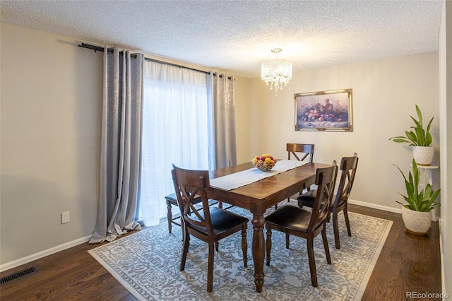 dining space featuring an inviting chandelier, dark hardwood / wood-style flooring, and a textured ceiling