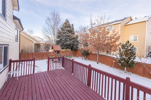 snow covered deck featuring a playground