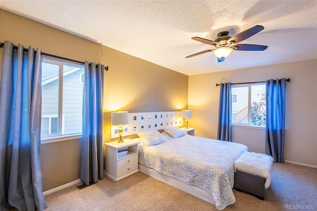 bedroom featuring light carpet, a textured ceiling, and ceiling fan