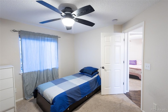 carpeted bedroom featuring a textured ceiling and ceiling fan