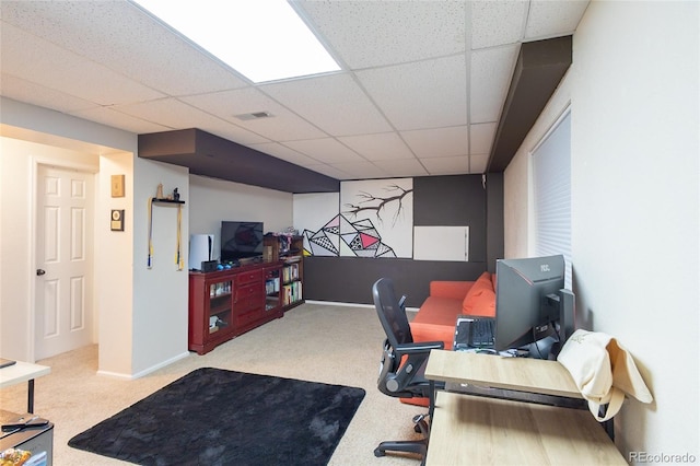 carpeted home office featuring a paneled ceiling