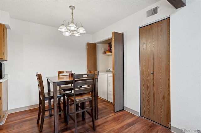dining area with visible vents, an inviting chandelier, dark wood-style flooring, a textured ceiling, and independent washer and dryer