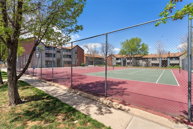 view of sport court featuring fence and a residential view