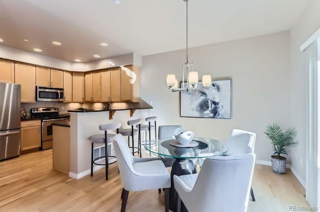 dining space featuring an inviting chandelier and light wood-type flooring