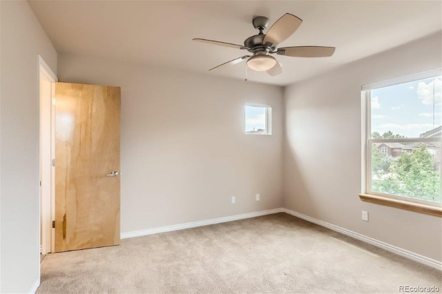 carpeted spare room featuring ceiling fan