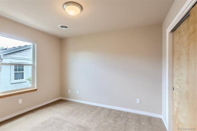 unfurnished bedroom featuring light carpet and a closet